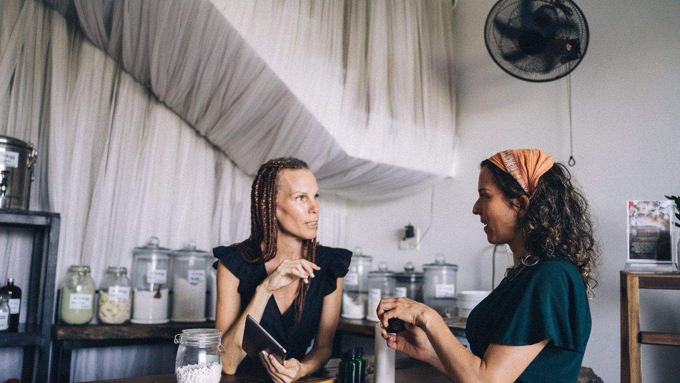 Small business owner listening to a customer across the counter