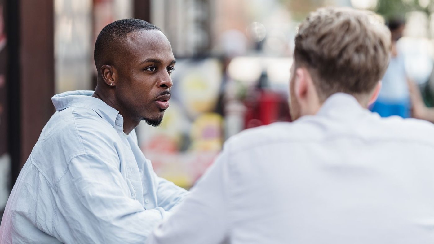 Two people in a serious conversation across a table